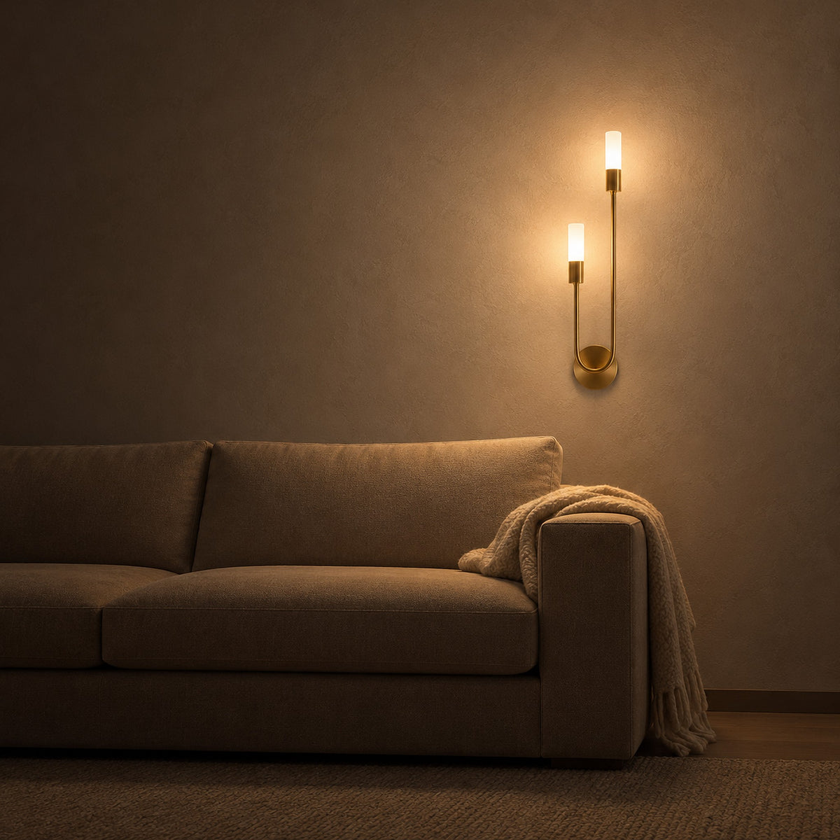 Amolven gold wall lamp with both heads lit above a sofa in a living room at night