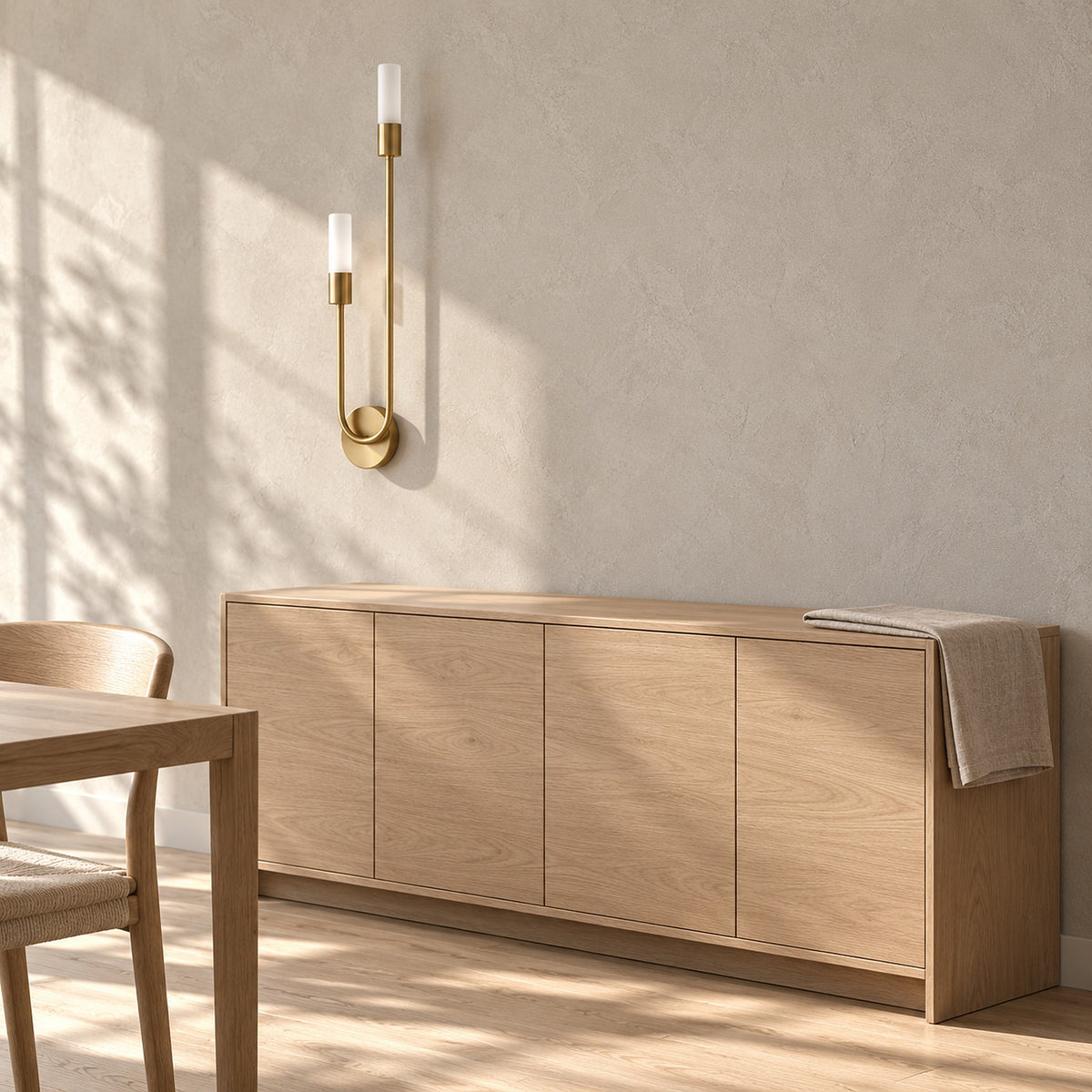 Amolven gold wall sconce unlit above a sideboard in a daylit dining room