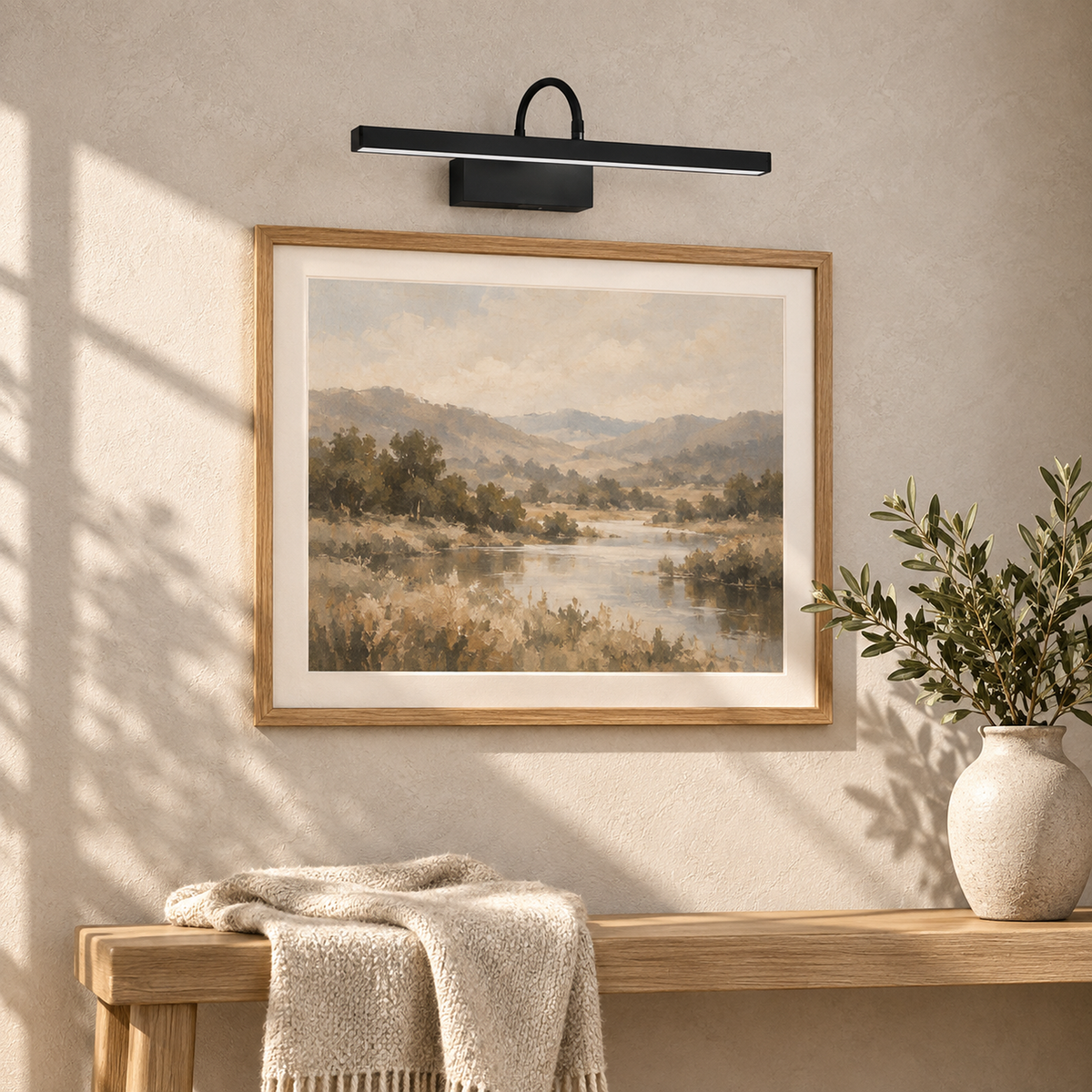 Anvelio black battery operated wall sconce mounted above framed art in a sunlit entryway
