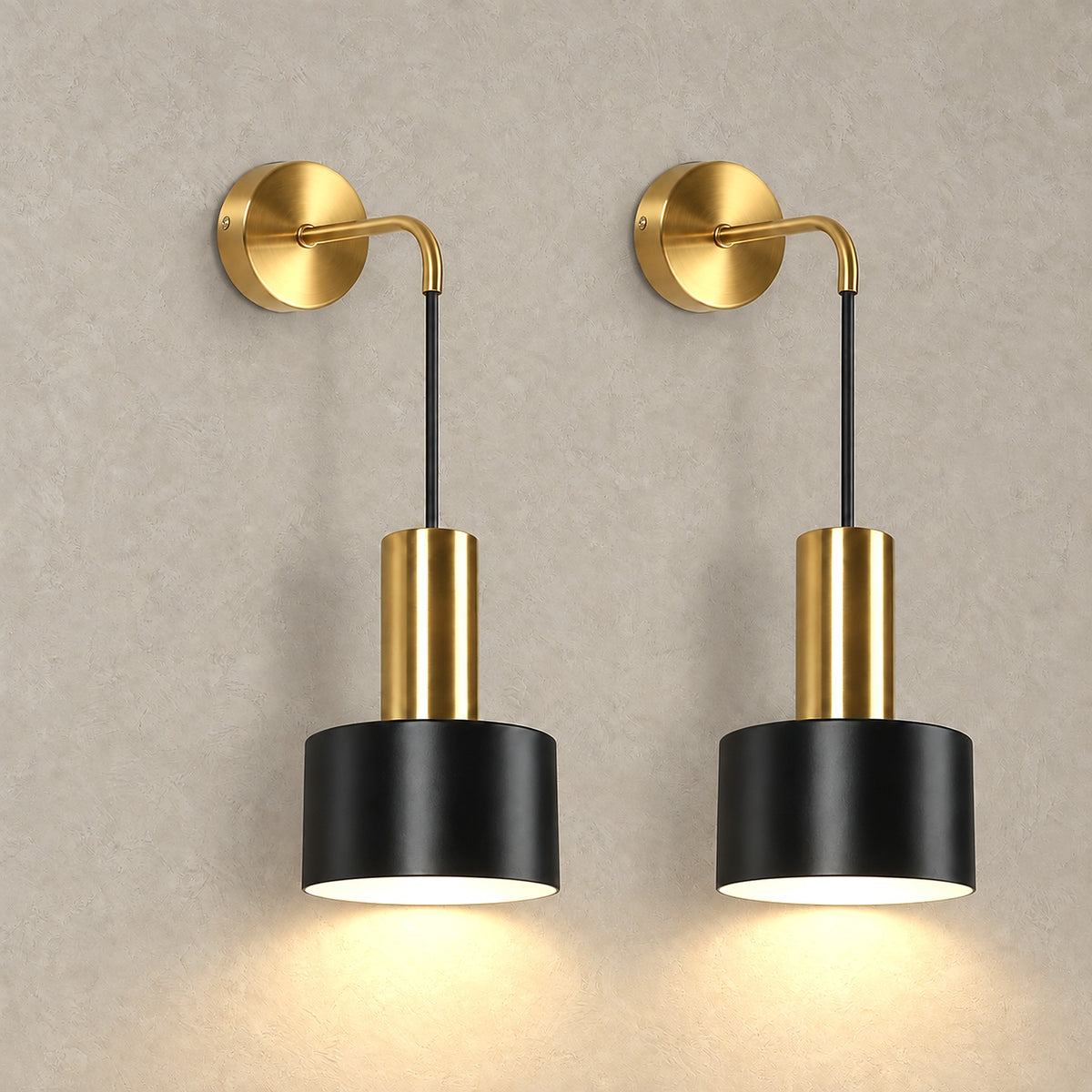 Arsomel black and gold battery operated wall sconce pair lit up against a plain backdrop