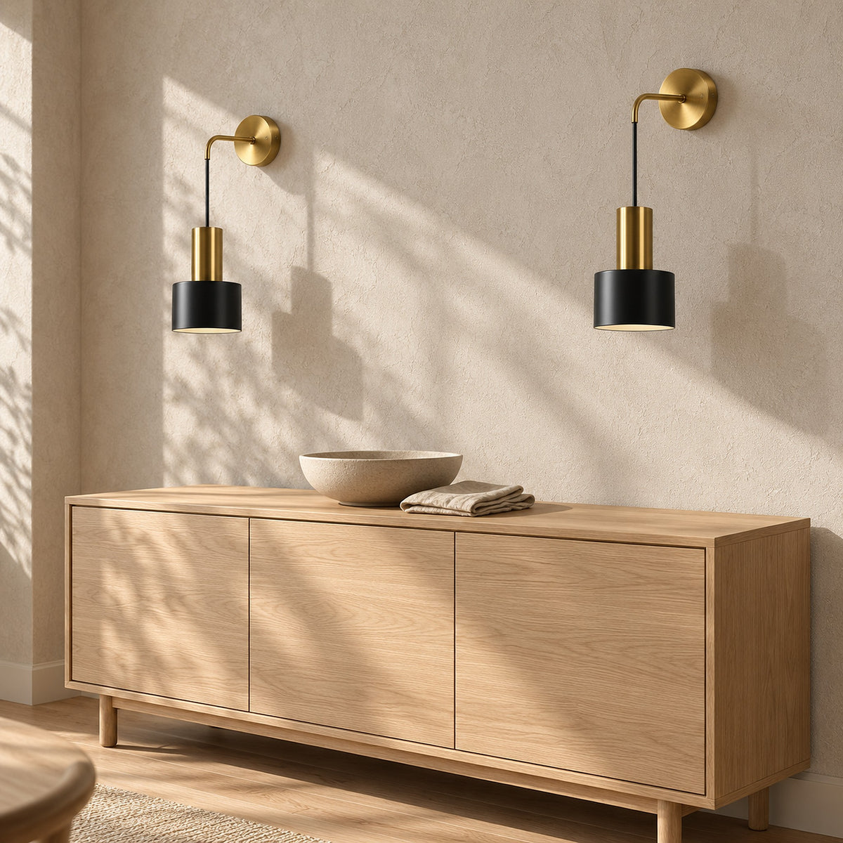 Arsomel black and gold wall lamp pair switched off above a dining room sideboard in sunlight