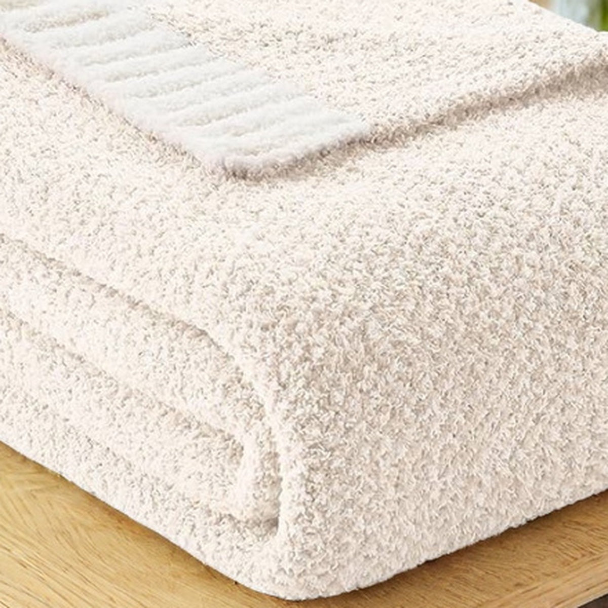 Calemira ivory throw blanket in close up showing the fine heathered knit face and one relaxed corner