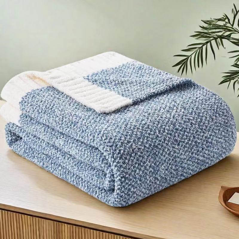 Calemira pale blue throw blanket folded on a wooden sideboard, showing its white ribbed end band