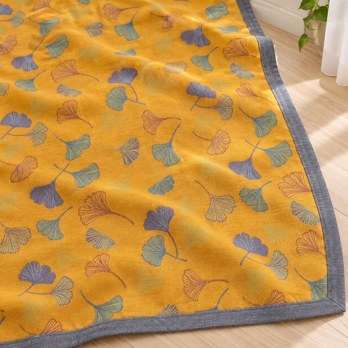 Calimor ginkgo leaf soft throw blanket in mustard yellow and gray in close view showing scattered leaf motifs
