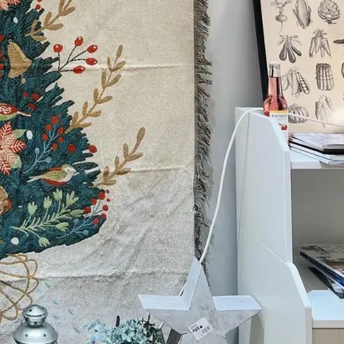 Canelvi christmas jacquard throw blanket hangs beside a white shelf, showing part of a tree design and fringed edge.