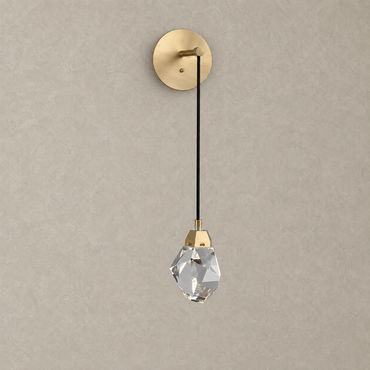 Caresilo brass color crystal wall sconce unlit against plain plaster wall