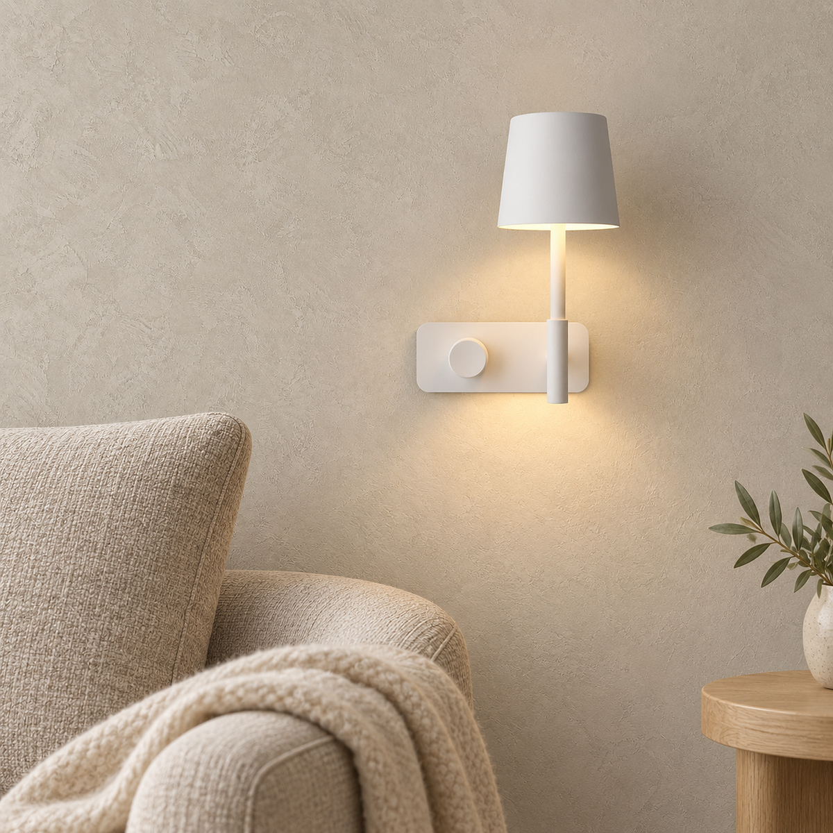 Cavolire white wall light glowing warm above an oatmeal armchair in a living room corner