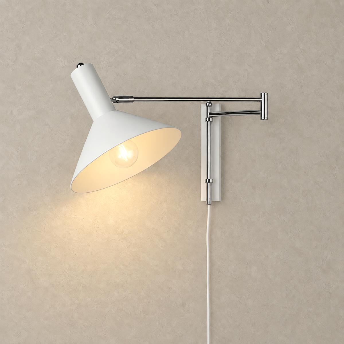 Celmoira white wall mounted bedside lamp casting light beneath its metal cone on a plain background