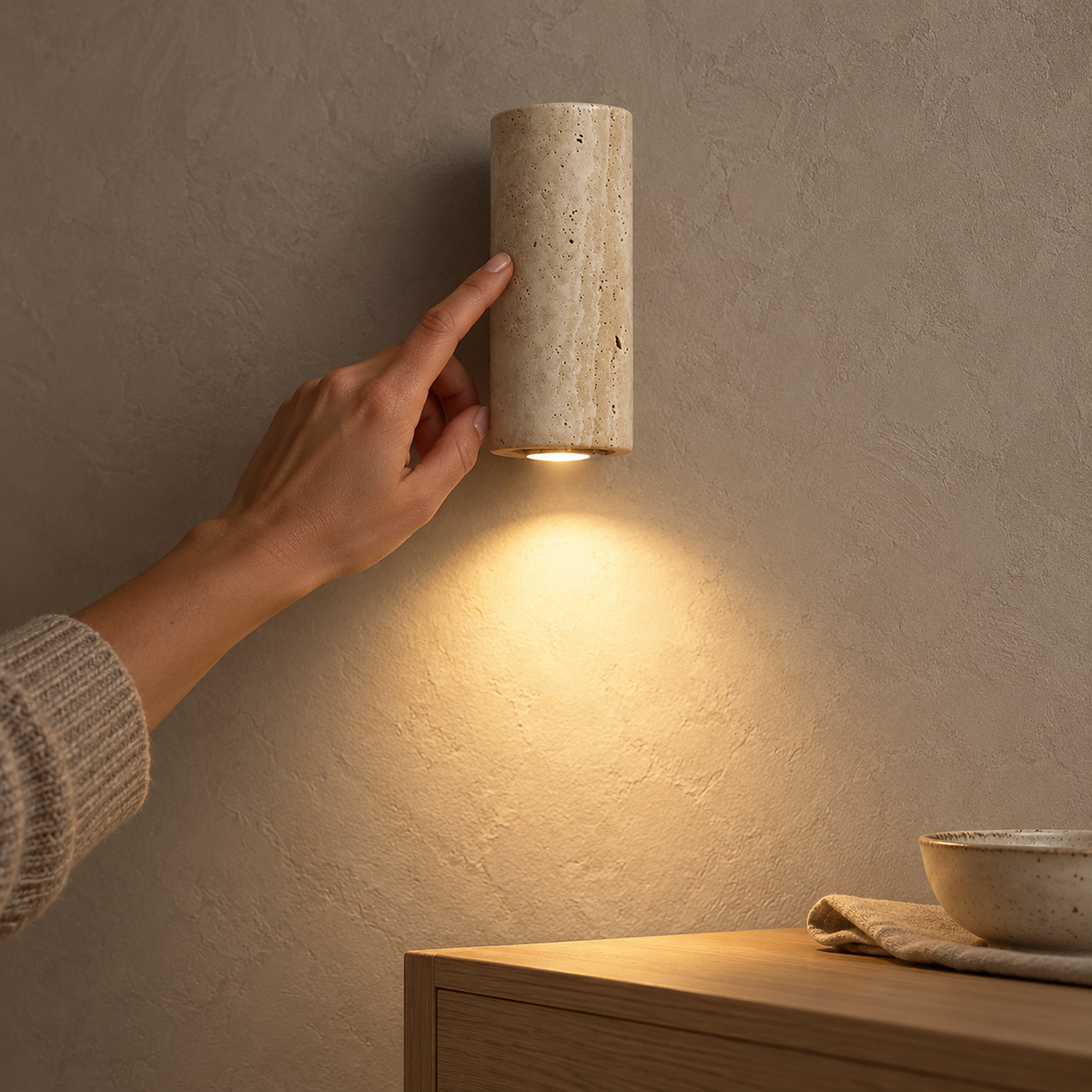 Cimorela pale travertine wall light glowing softly in the late afternoon
