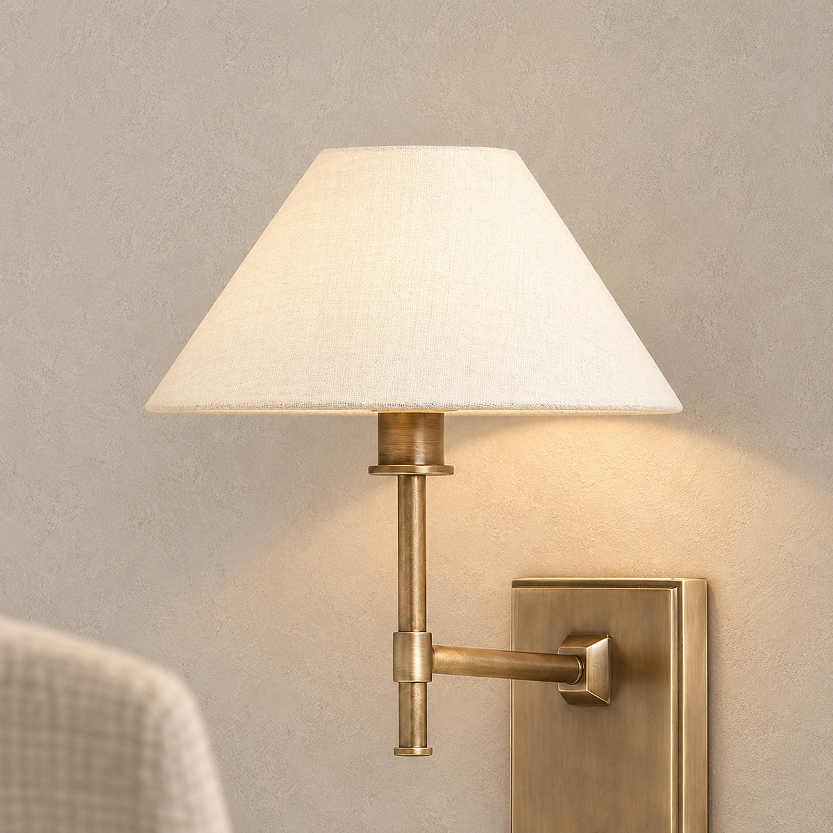 Ciralmo gold rechargeable wall sconce lit with its fabric shade in a daylight dining nook