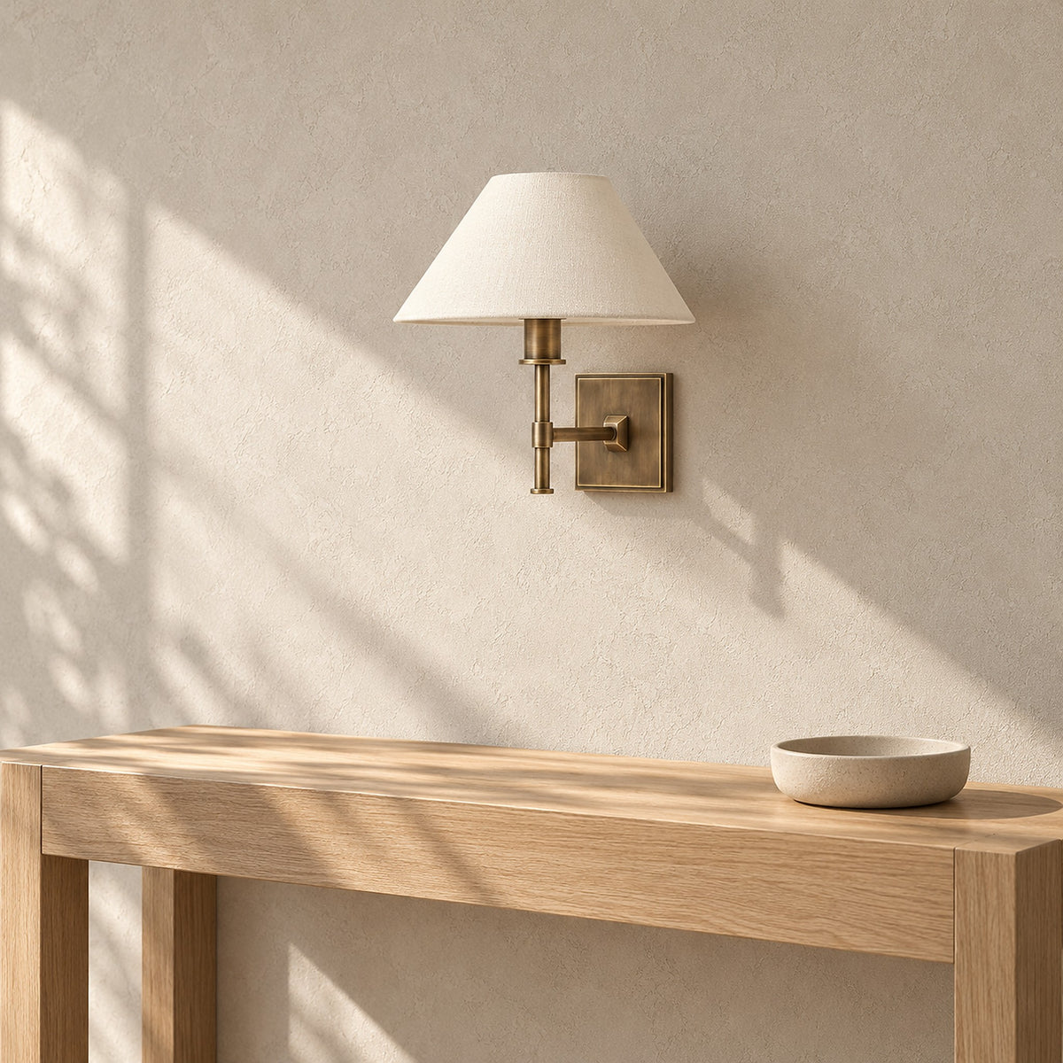 Ciralmo gold wall light unlit above a pale console in an entry vestibule