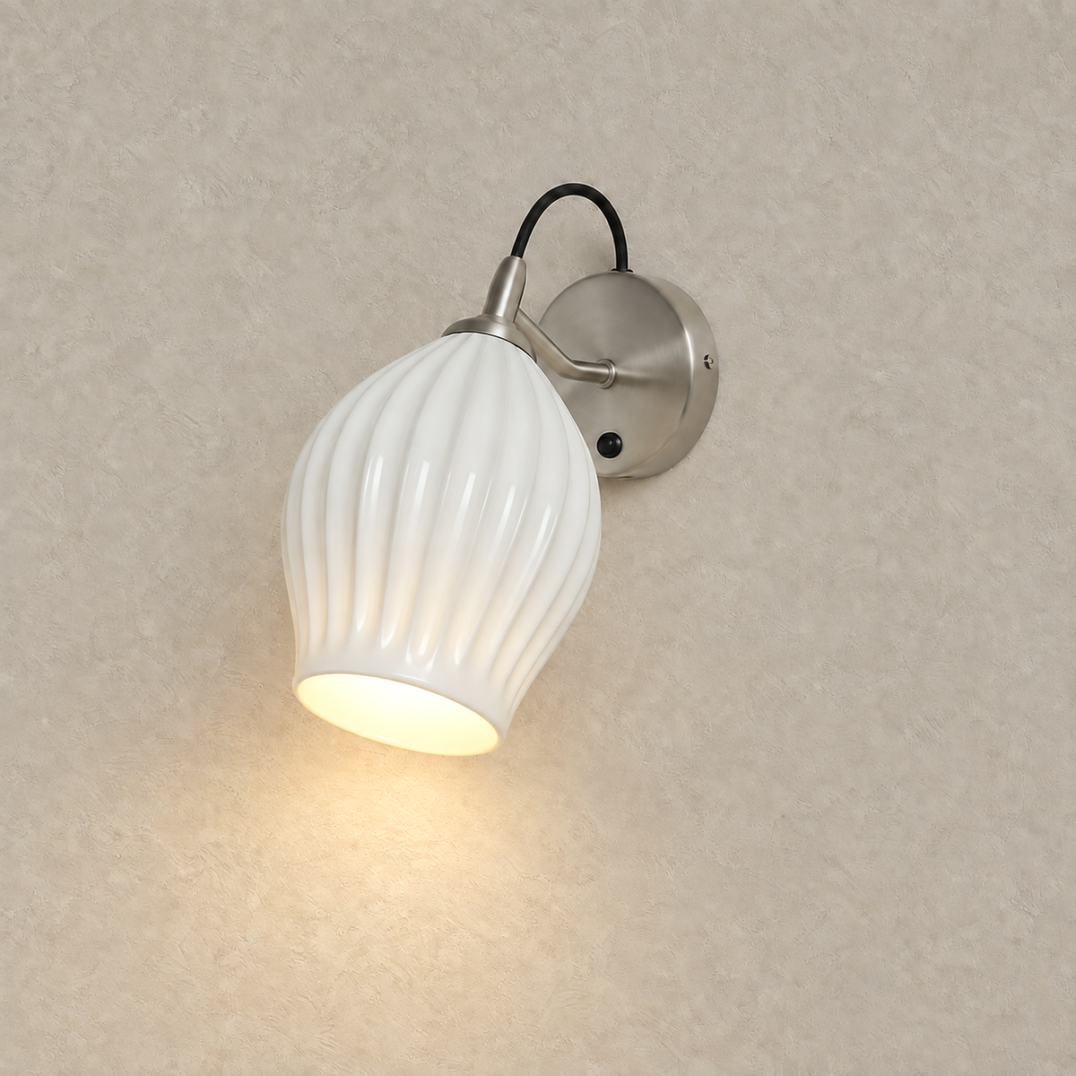 Comirel chrome LED wall sconce lit and glowing against greige plaster