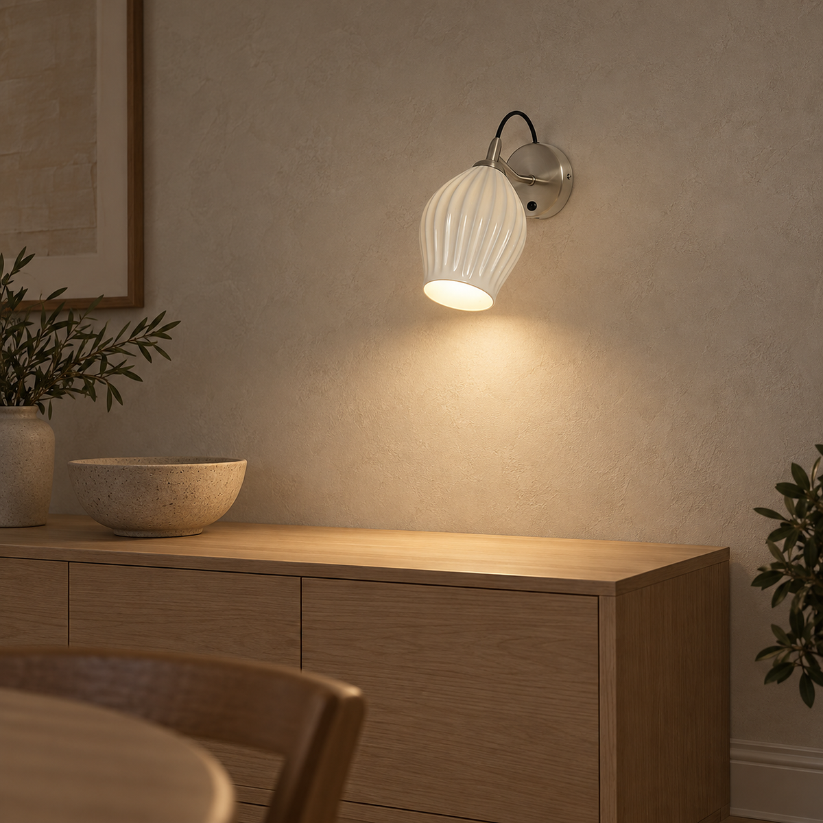 Comirel chrome wall lamp glowing above a clear dining sideboard