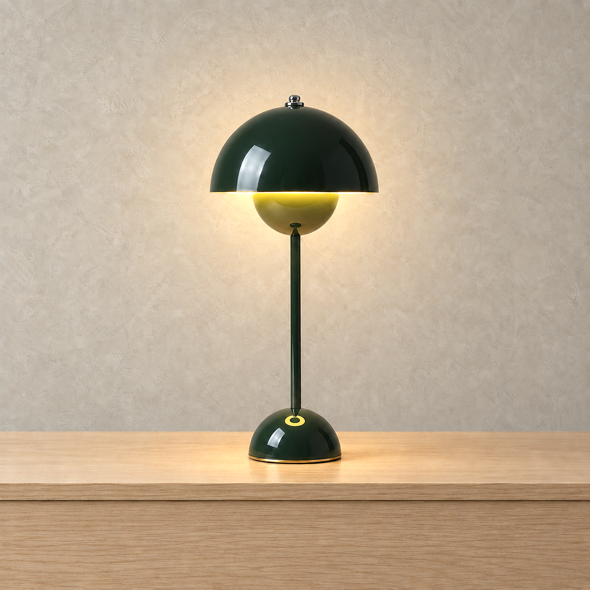 Coremila green bedside lamp glowing warm white against a plain plaster wall