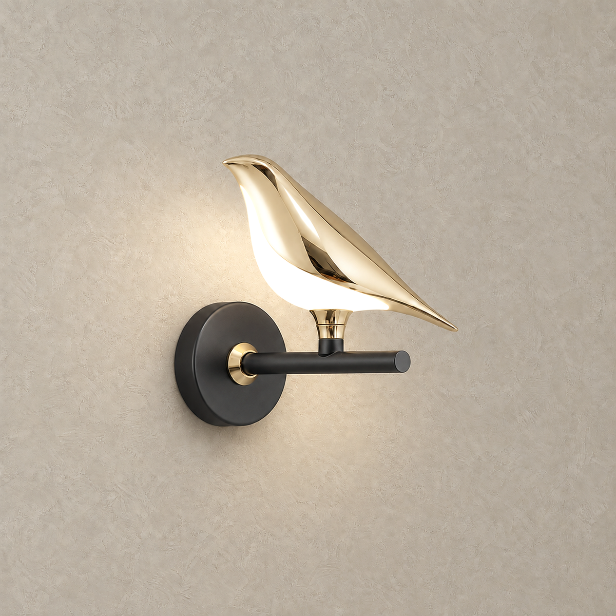 Corsavel 1 bird gold and black LED wall sconce lit up, its pale acrylic shade glowing beneath the bird