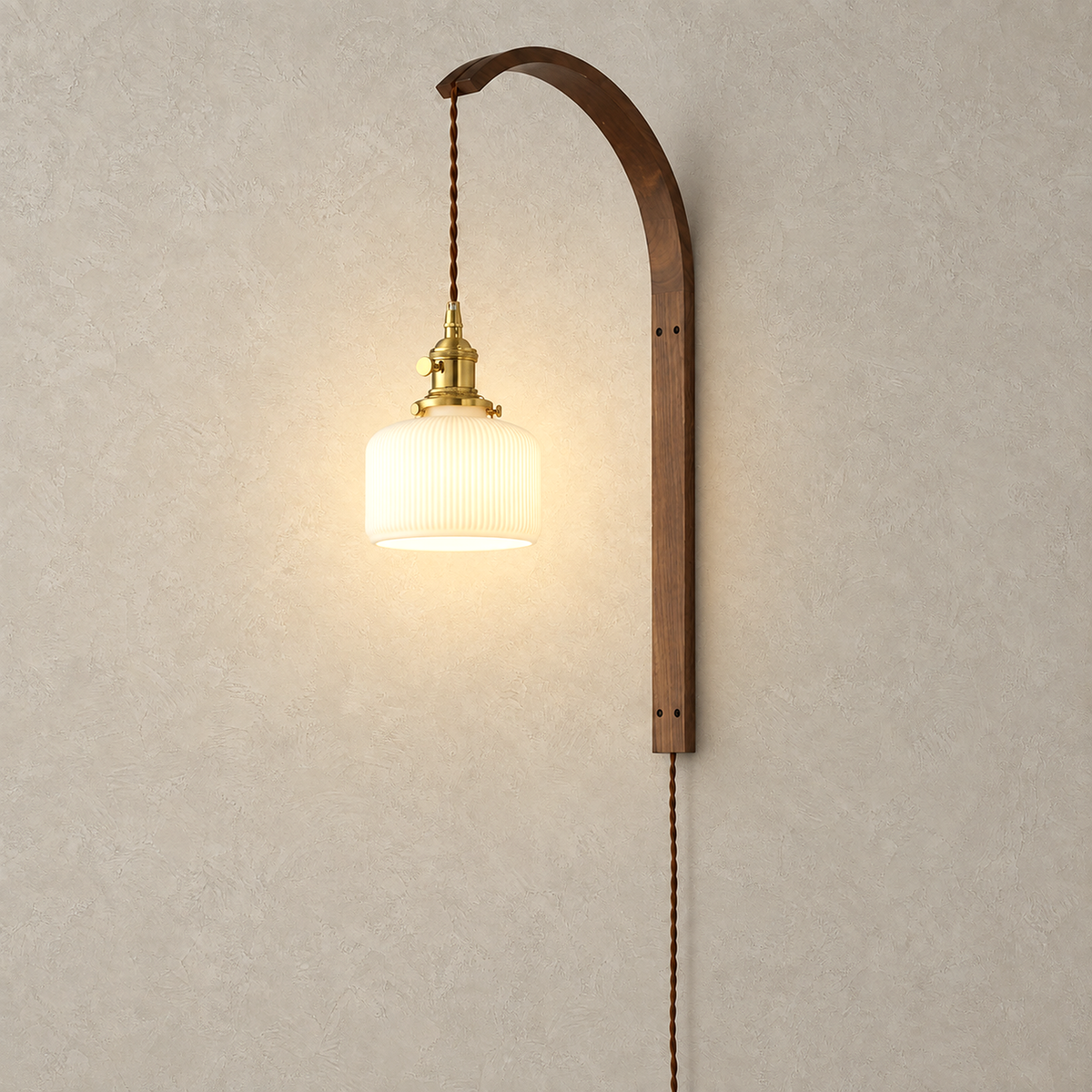 Cosineri walnut color plug in wall sconce model D lit on a plain plate with its white shade