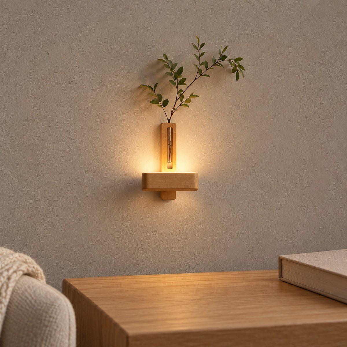 Ilaveno Natural wall sconce glowing with leafy stems above a wooden table with a closed book beside seating