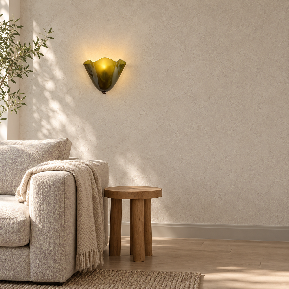 Ilsaren green plug in wall lamp glowing above a living room sofa by day