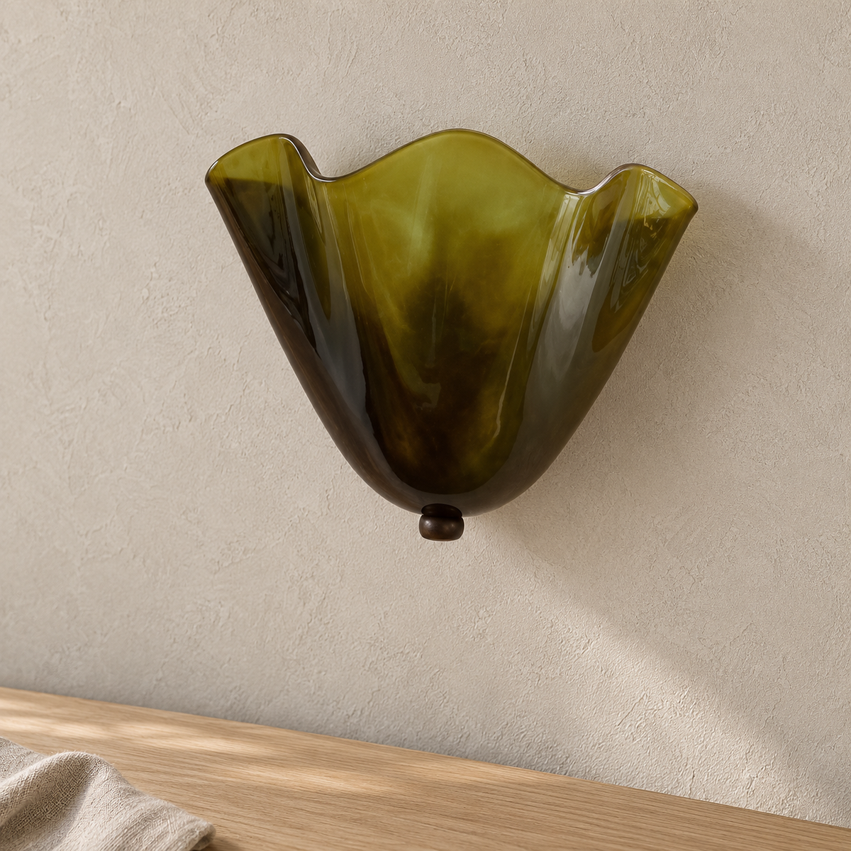 Ilsaren green wall lamp close up, the folded glass shade showing its scalloped upper rim