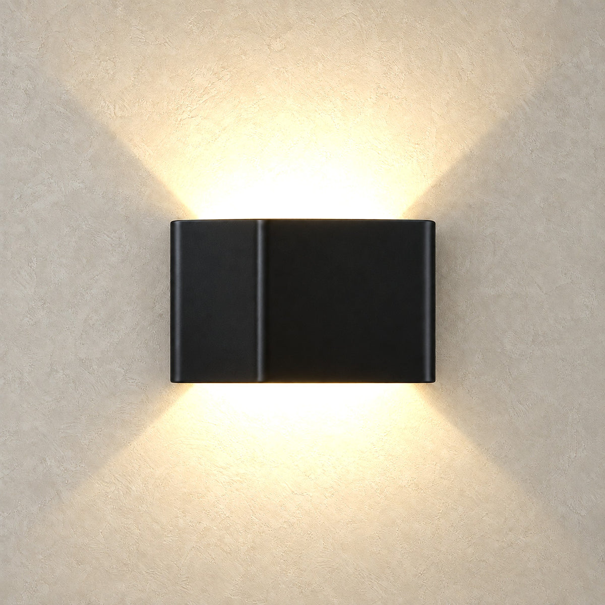 Ivelmo black LED wall sconce casting two fans of warm light up and down the wall
