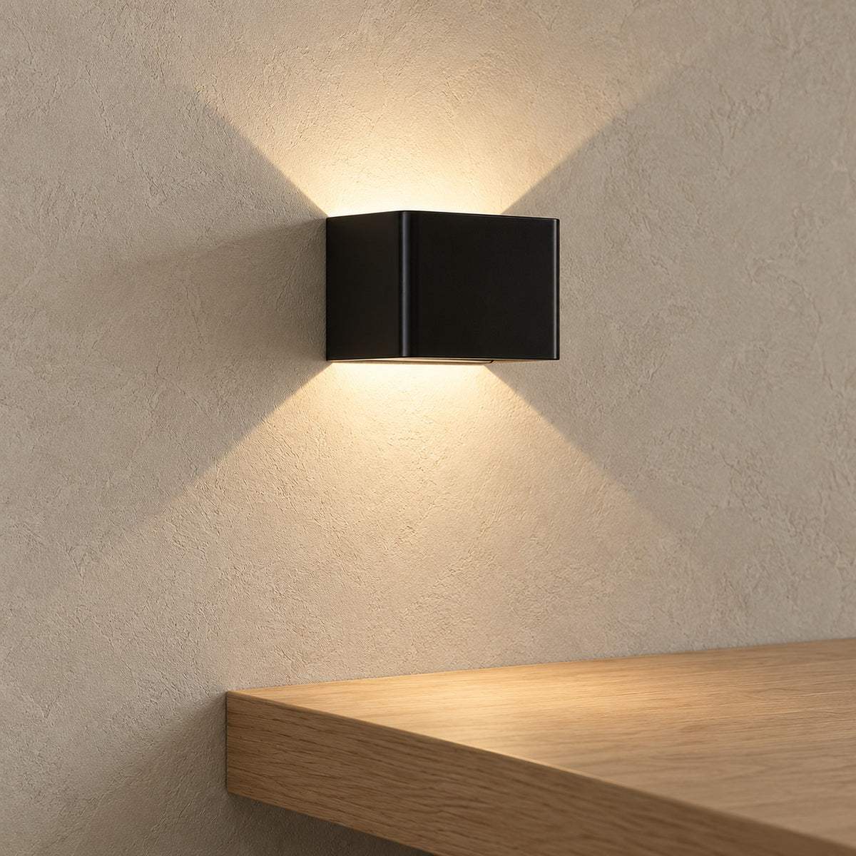 Ivelmo black rechargeable wall sconce casting warm light above a living room ledge