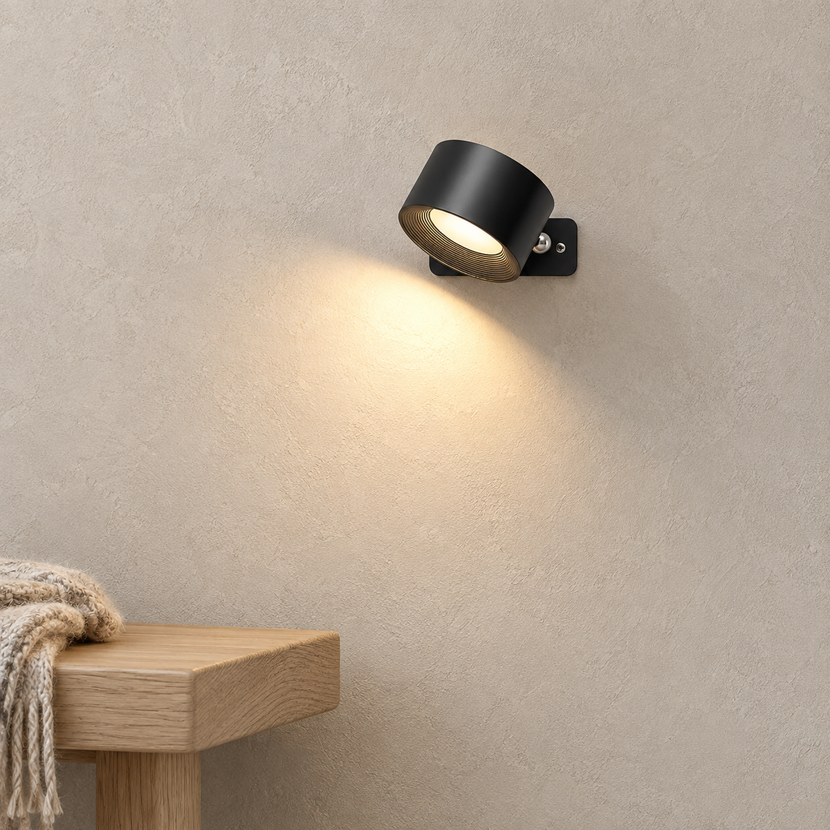 Lasirel black LED wall sconce lit on the wall beside an entryway bench