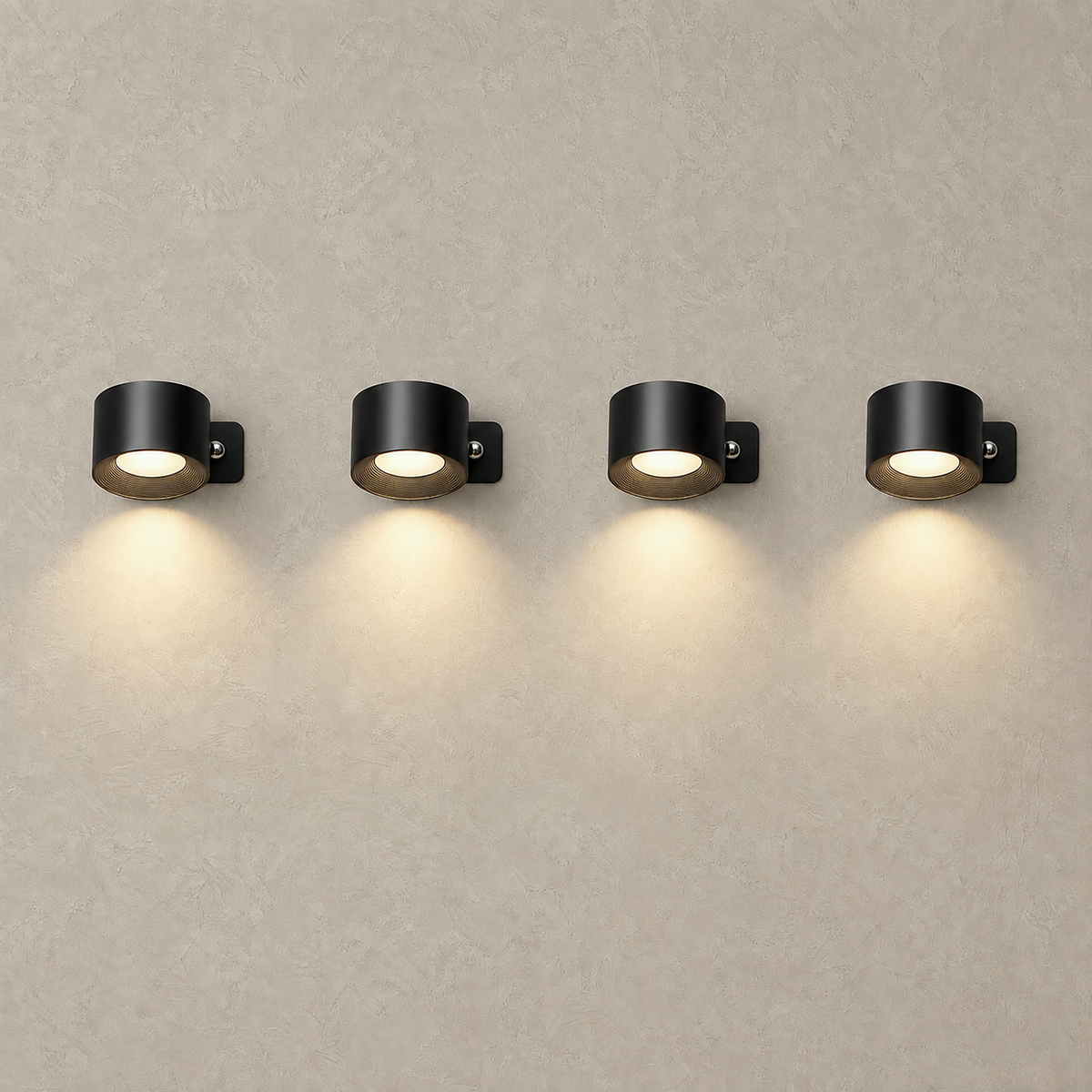 Lasirel black LED wall sconce set of 4 lit and arranged on a plain studio plate