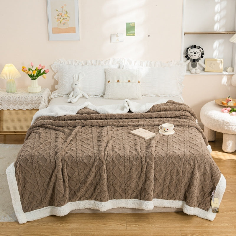 Lerivosa reversible fleece throw blanket spread over a bed, showing a brown textured side and white fleece edges.