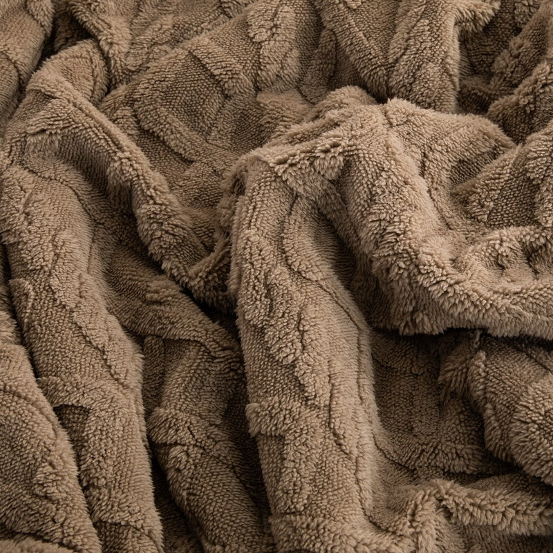 Lerivosa reversible fleece throw blanket in gathered folds, showing a close up of its textured brown surface.