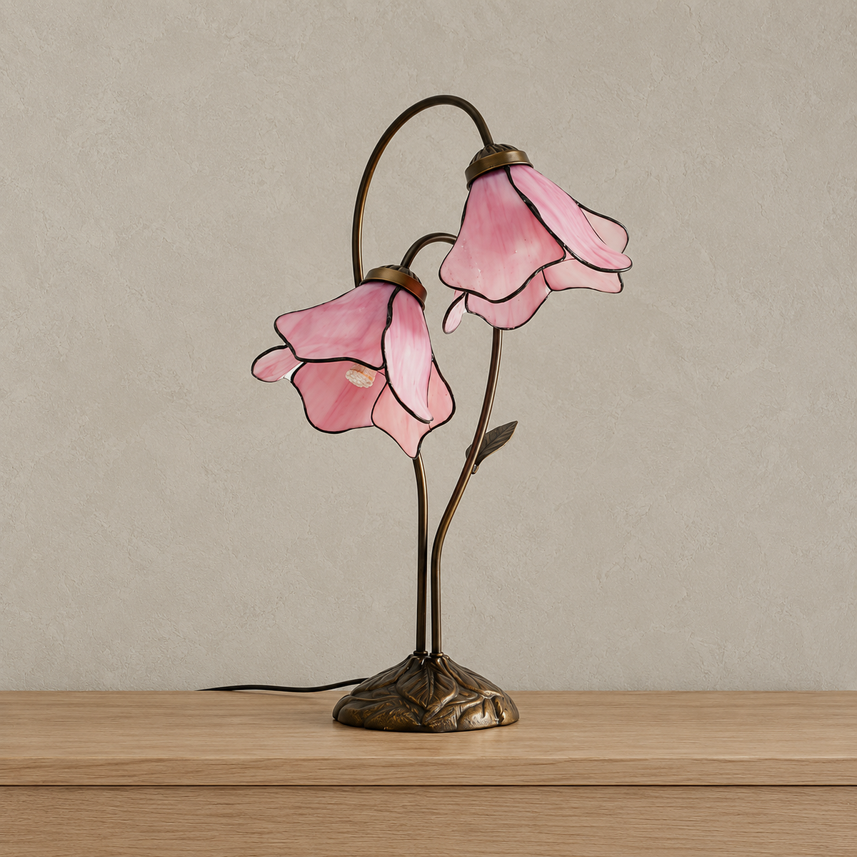 Linavor stained glass table lamp in pink with both glass flower shades unlit on a plain backdrop