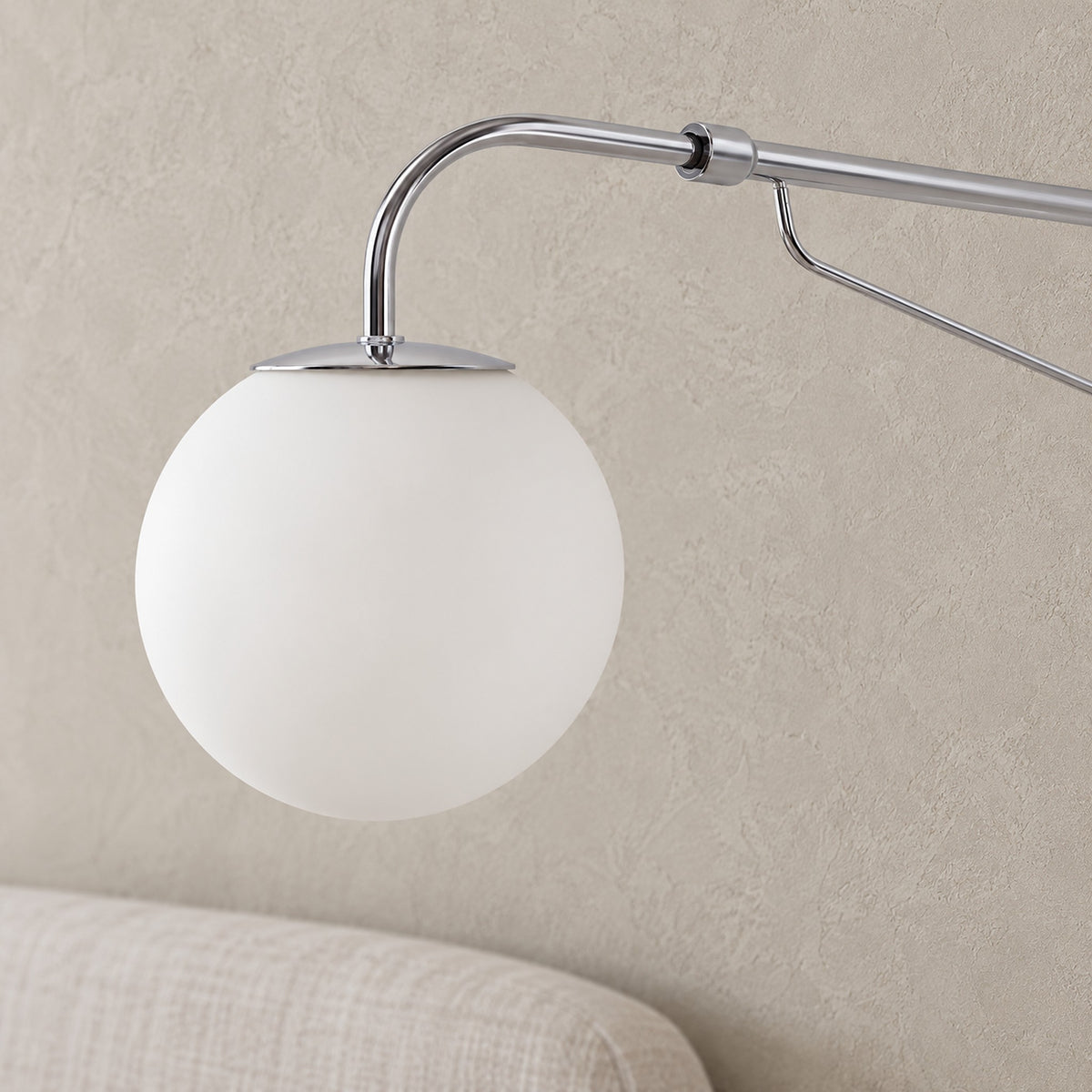 Lirelso chrome and white wall sconce, close detail of frosted globe on its chrome arm, takes an led wall sconce bulb
