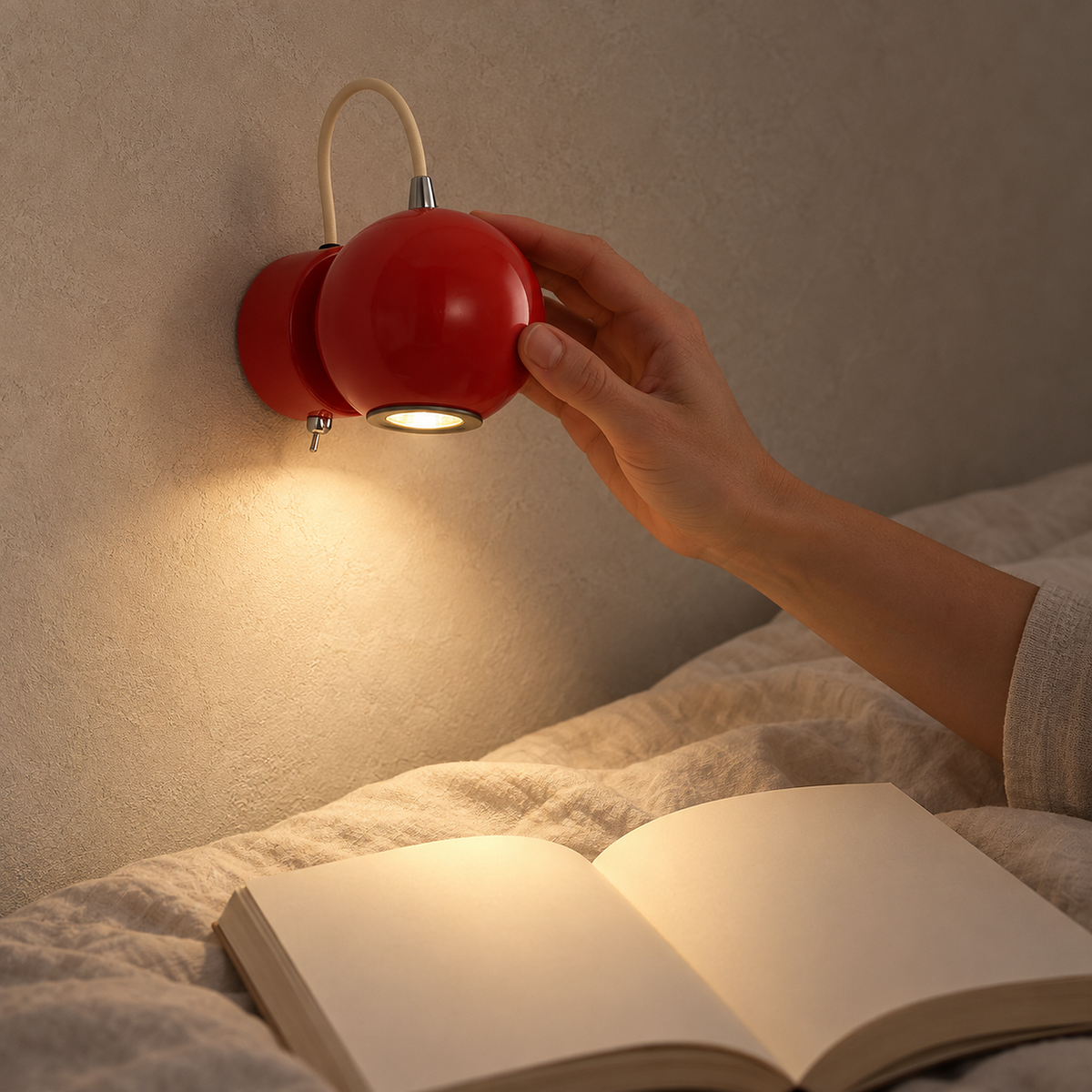 Lirema red hardwired wall sconce directing warm light toward the pages of a book in bed #color_red