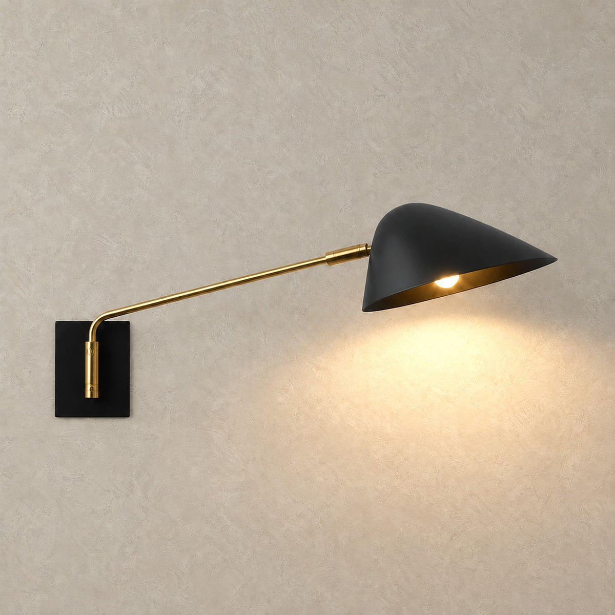 Lirmena black hardwired led wall sconce casting a warm downward glow from its wide shade
