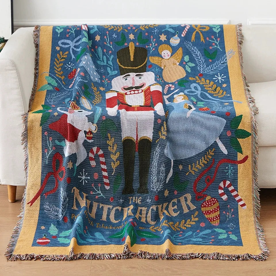 Lisorvan christmas cotton throw blanket draped over a white armchair, showing Nutcracker motifs and fringed edges.