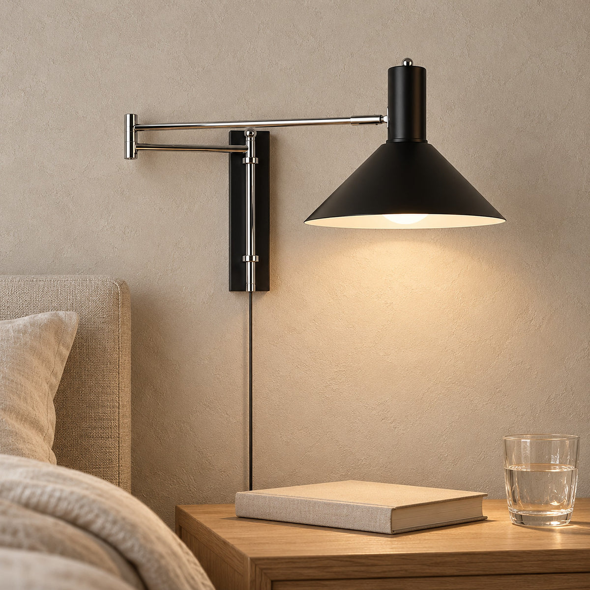Lomaresi black bedside wall light glowing above a clear nightstand in a guest sleeping alcove
