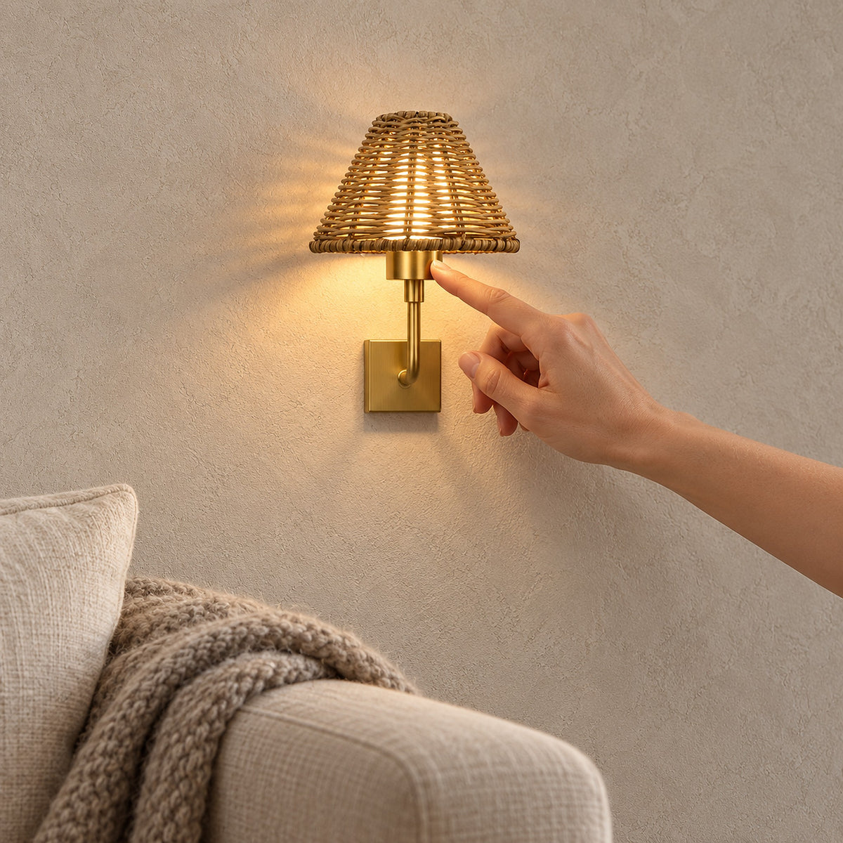 Lomarvi gold wall light glowing warm white beside a sofa in a bright living room