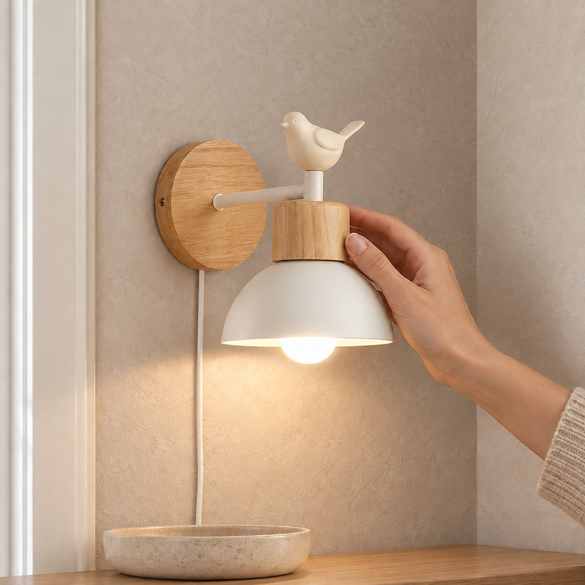Lorsenta white plug in wall lamp with cream bird ornament and wood toned mount beside a window