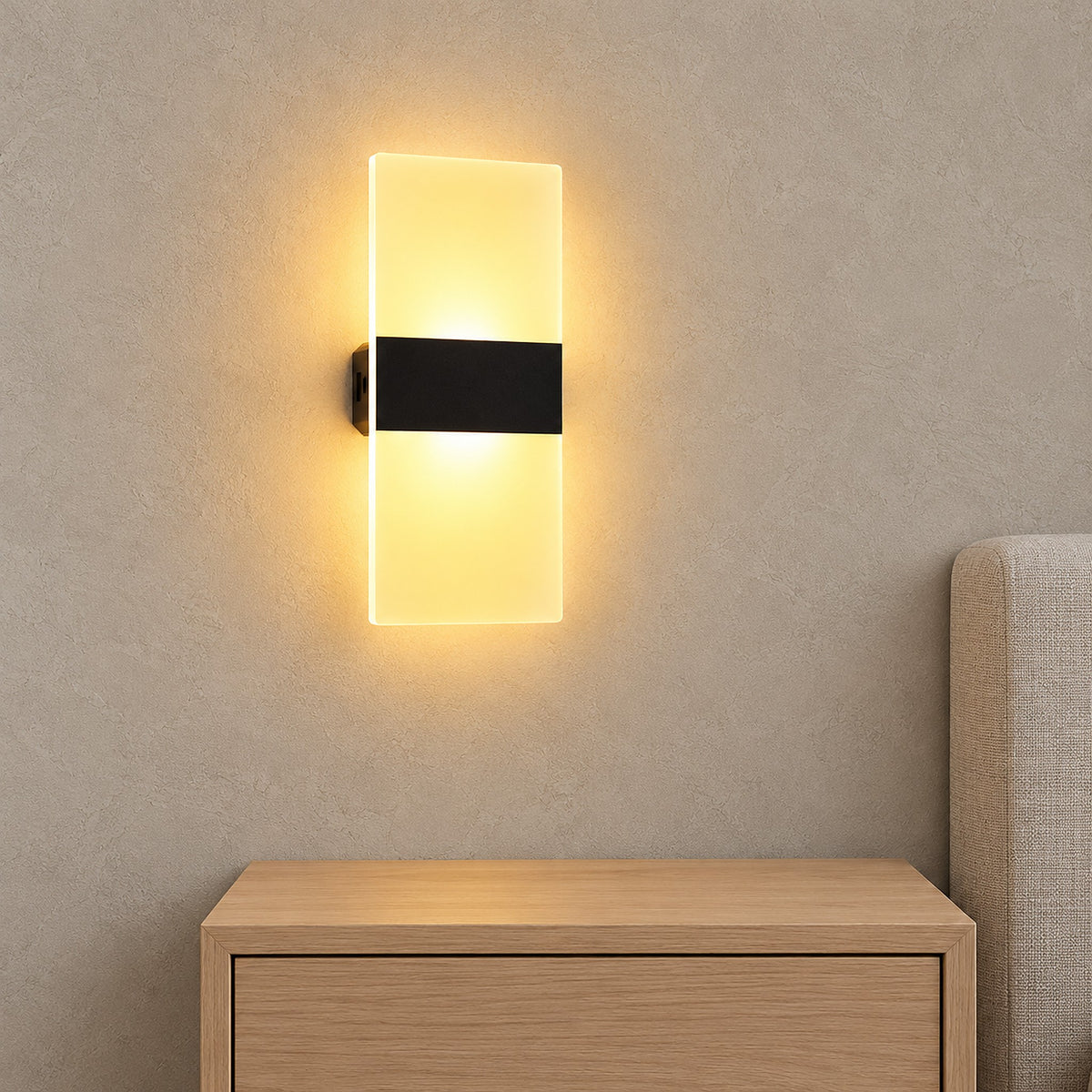 Melavor black cordless wall lamp glowing above a bedside table in a bright bedroom