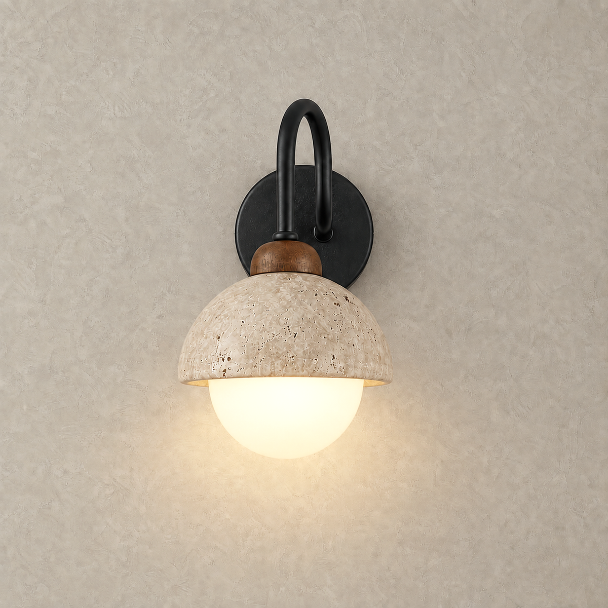 Meratilo yellow travertine and black hardwired wall sconce lit with white globe and soft wall glow