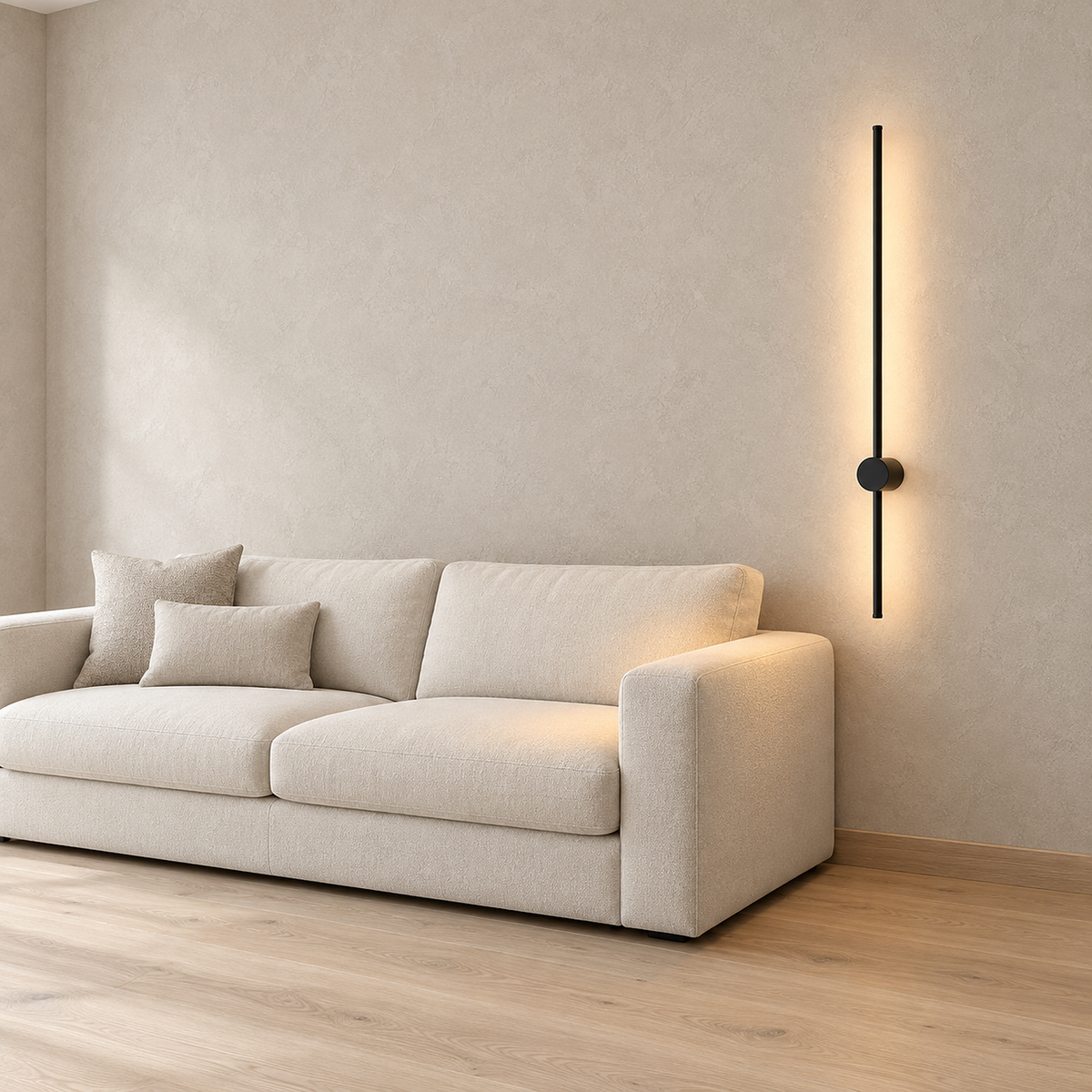 Merisano black wireless wall light lit beside an oatmeal sofa, warm light on the corner seat