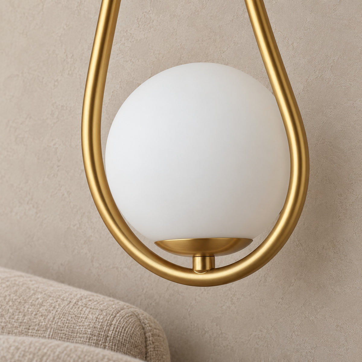 Mesaril gold wall lamp close up of the glass shade and painted metal frame