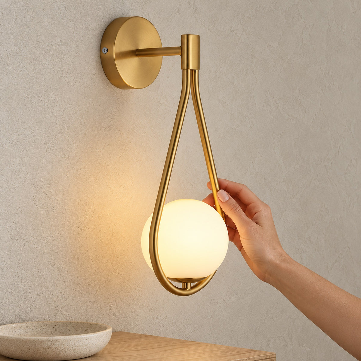 Mesaril gold wall light in an entryway, detail of the backplate and projecting arm