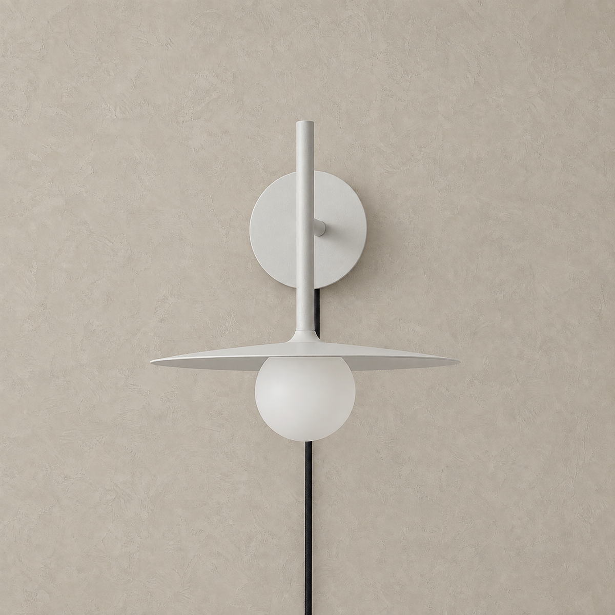 Milvaro white plug in wall sconce unlit showing its wide metal disc and frosted glass globe