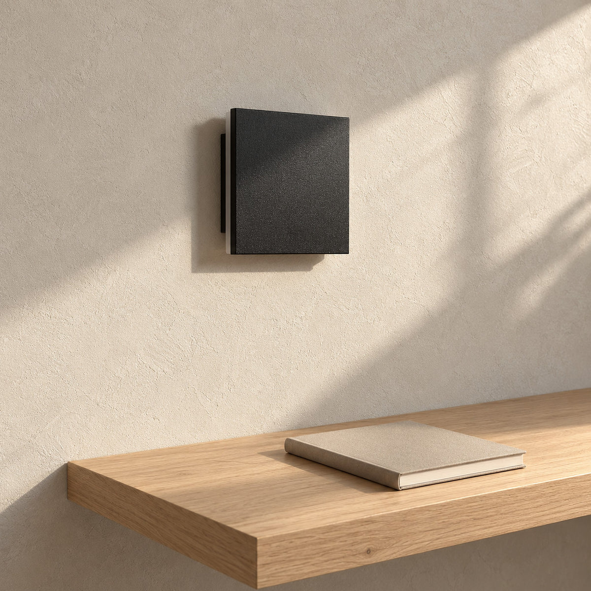 Mivorel black square wall lamp shown unlit on a sunny study wall in daytime