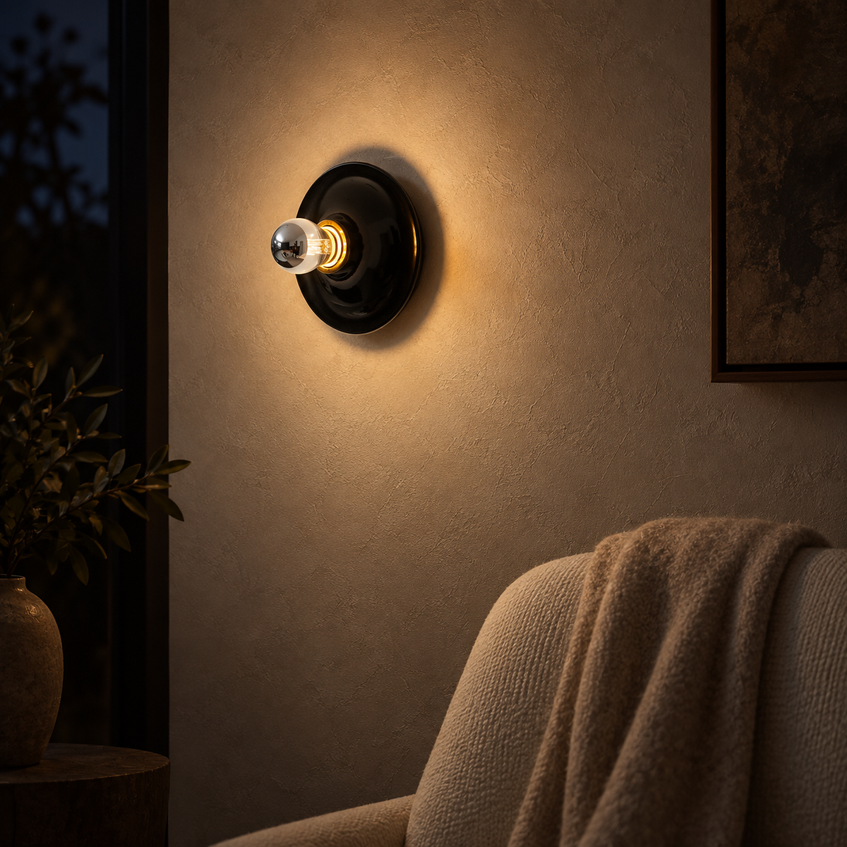 Monterla black plug in wall light illuminating a snug seating corner after dark #color_black