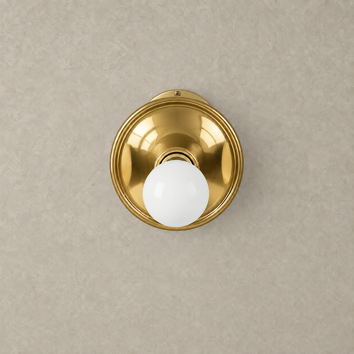 Monterla gold wall sconce unlit with its reflective plated metal dish #color_gold