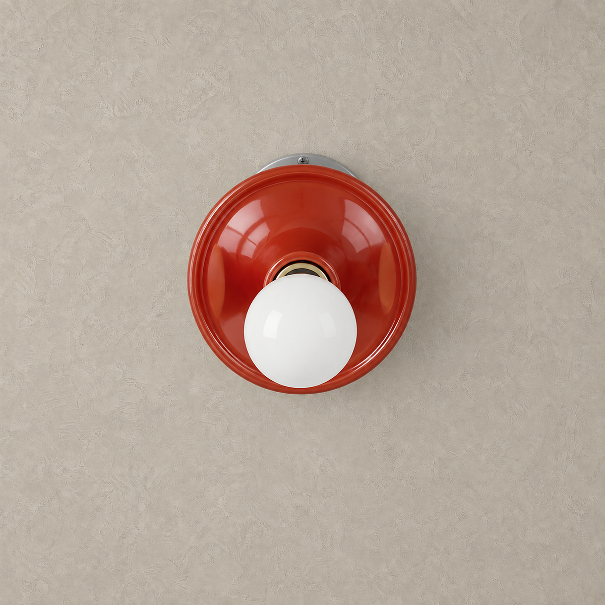 Monterla red plug in wall sconce shown unlit with its smooth circular metal dish