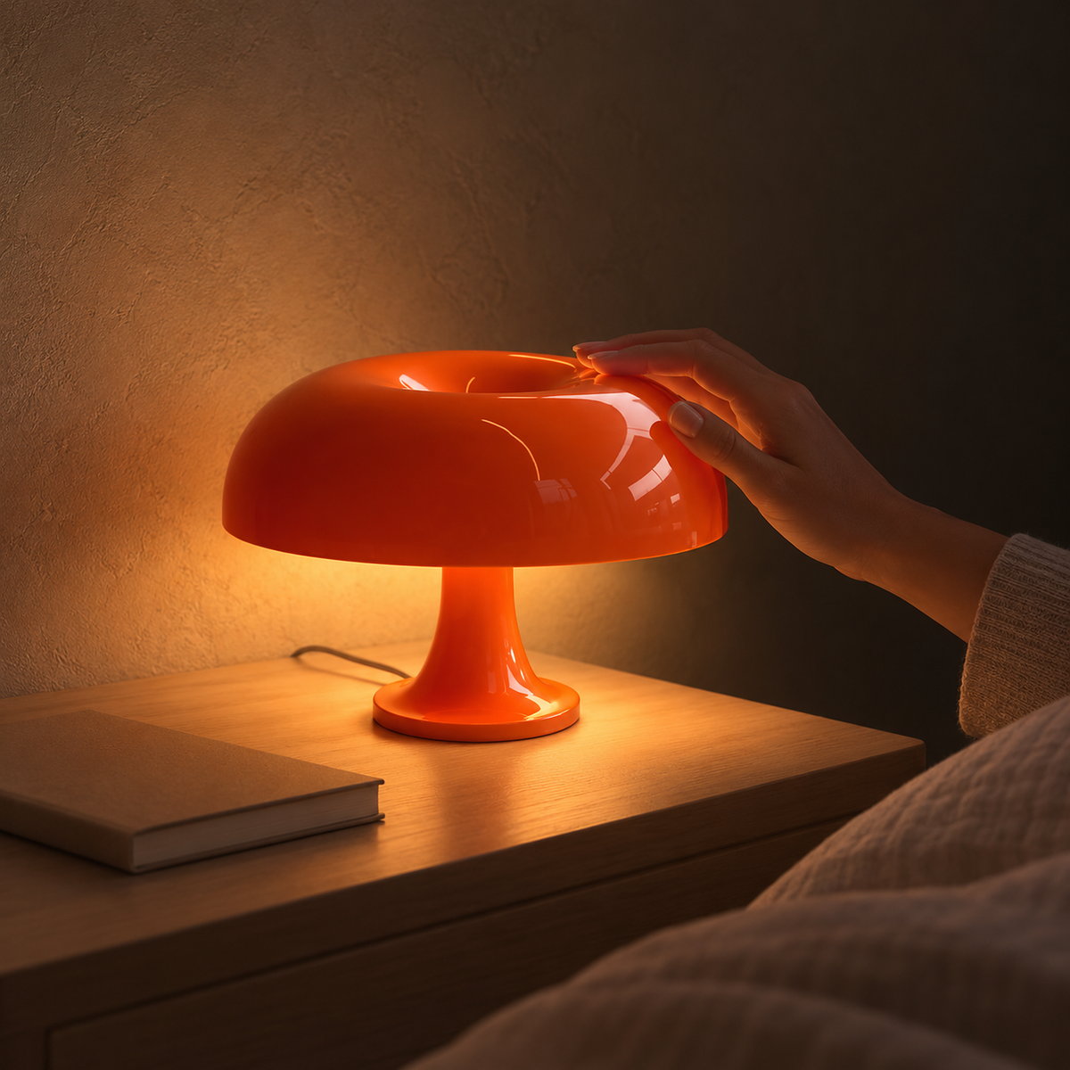 Moranel orange bedside lamp spilling warm light across the nightstand in a bedroom at night