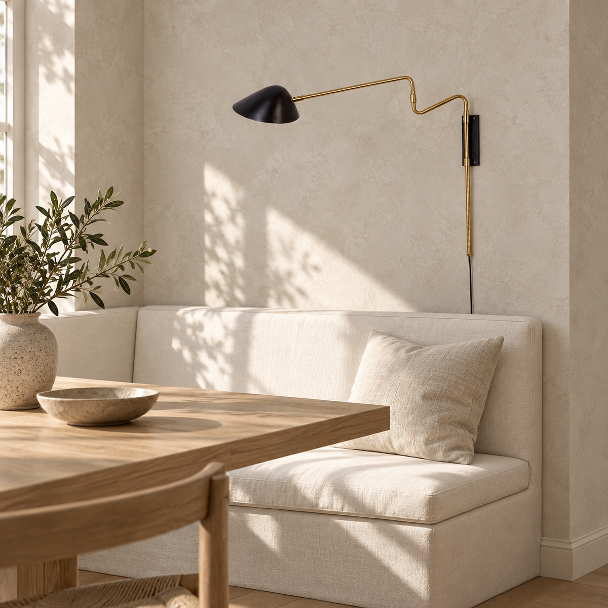 Movresa black wall lamp switched off above a sunlit ivory dining banquette