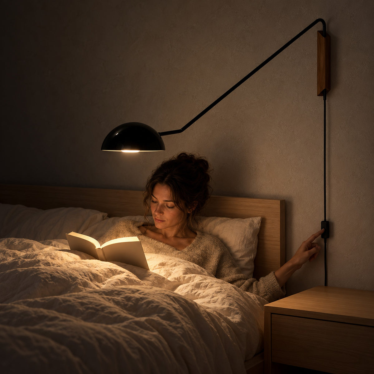 Nalesio black bedside wall light giving warm light to a reader in a guest bedroom after dark